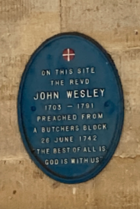 Blue Plaque on a wall which reads "on this site the revd John Wesley 1703-1791 preached from a butchers block 28June 1742 The best of all is God with us.